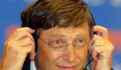 Microsoft founder Bill Gates adjusts his headphones at a seminar at the China International Services Convention in Beijing Wednesday June 30, 2004. Gates is in Asia to hold talks with Asian governments to offer tailored, cheaper versions of its Windows operating system geared toward bringing computer skills to millions of poorer people. (AP Photo/Greg Baker)