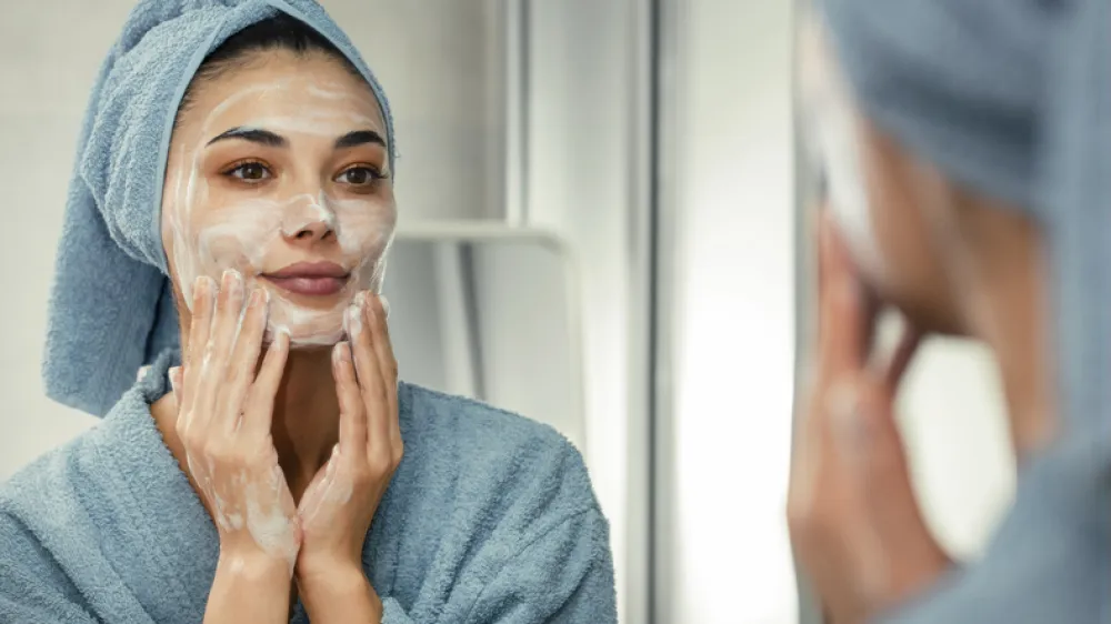 Reflection in a mirror beautiful woman washing her face