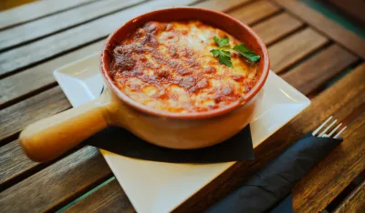 Close up shot of a freshly baked lasagna in a round pot.