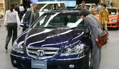 Visitors to the headquarters of Honda Motor Co. in Tokyo take a close look at Legend, one of the Japanese automaker's latest popular vehicles, Wednesday, Oct. 27, 2004. Honda reported record fiscal first half profits in the day on strong sales in Asia and Europe, and raised its earnings forecast for the full year. (AP Photo/Itsuo Inouye)