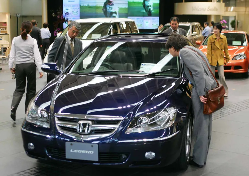 Visitors to the headquarters of Honda Motor Co. in Tokyo take a close look at Legend, one of the Japanese automaker's latest popular vehicles, Wednesday, Oct. 27, 2004. Honda reported record fiscal first half profits in the day on strong sales in Asia and Europe, and raised its earnings forecast for the full year. (AP Photo/Itsuo Inouye)