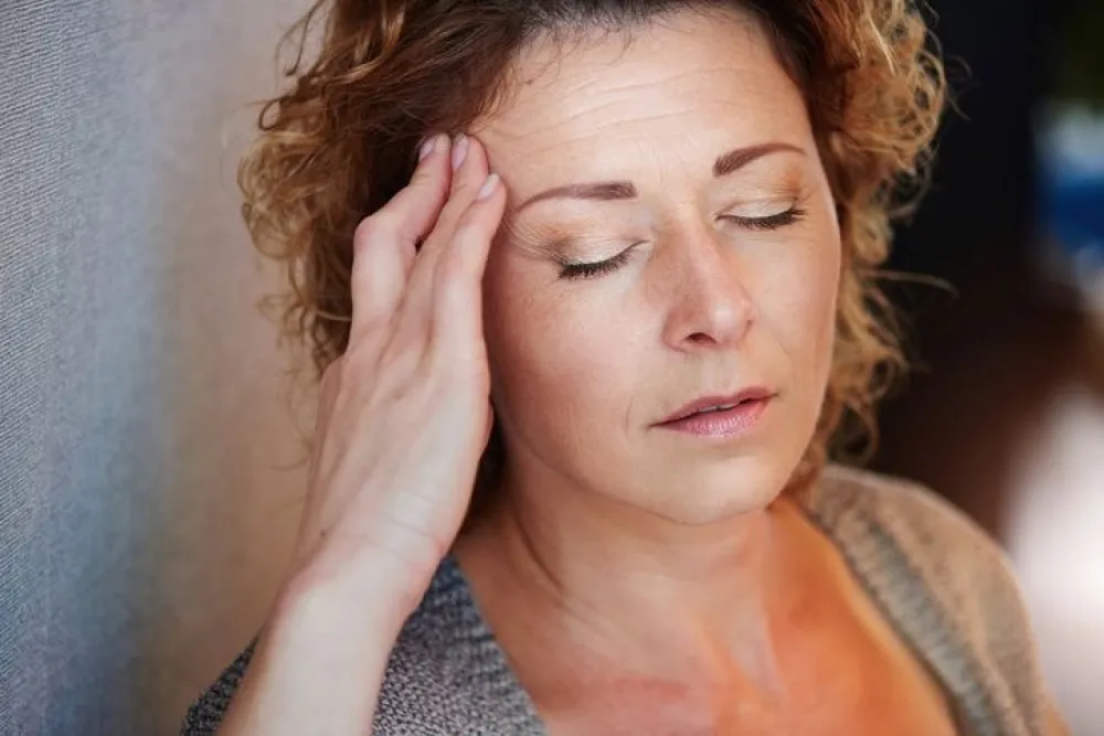 Close up portrait of older woman with hand to head in pain