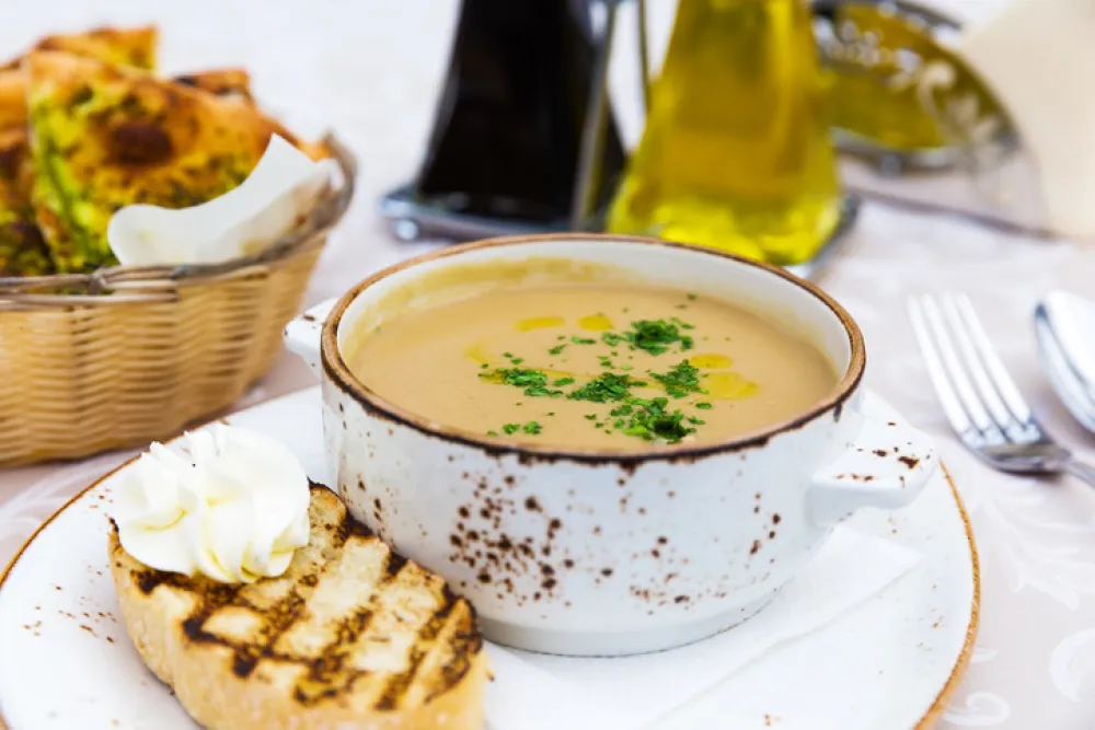 Close up of bowl with mushroom cream soup with green parsley