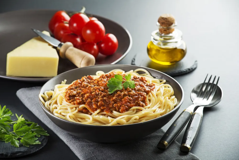 Delicious spaghetti with bolognese sauce served on a black plate